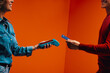 © Jacob Lund - Tap to pay technology for seamless shopping transaction in orange monochromatic set