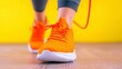 © aun - Bright Orange Sneakers in Motion Against a Vibrant Yellow Background