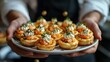 © Антон Сальников - Waiter serving finger food and dessert on a tray at a cocktail party or event catering, shown in closeup
