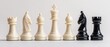 © Bassmallah - White chess pieces lined up against two black chess pieces on a white background.