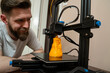 © phoenix021 - Man looking from close distance how his 3d printer works in his home