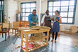© Caia Image - Group of artisans making woven furniture in workshop