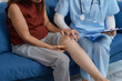 © amnaj - Female doctor examining senior woman suffering from knee pain during home visit