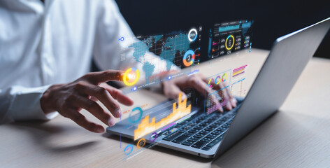 A businessman uses a laptop to access an AI-powered business analytics dashboard, showcasing charts, metrics, and KPIs. He analyzes performance data to generate. Data analysis concept. 