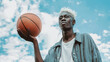 © OleksandrZastrozhnov - Basketball player holding ball against sky. African American athlete portrait. Street basketball.