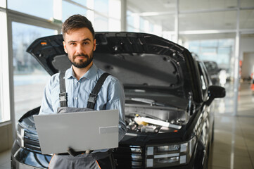 Fototapete - Mechanic Uses a Computer with an Augmented Reality Diagnostics Software. Specialist Inspecting Car's Engine to Quickly Spot Broken Components. Premium Car Service