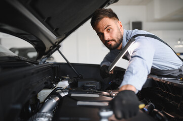 Leinwandbilder - Troubleshooting process. Auto mechanic working in garage. Repair service