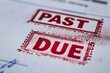 © Ruslan - A close-up image of a 'PAST DUE' stamp prominently marked on a stack of unpaid bills