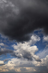 Wall Mural - Storm cloudy dramatic sky with dark rain grey and white cumulus cloud and blue sky background texture, thunderstorm, heaven