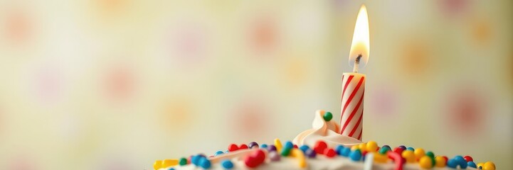 Wall Mural - Close-up shot of a single candle on top of a colorful birthday cake, minimalist dinnerware, soft light