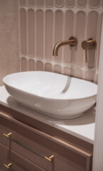 Modern white sink with faucet. bathroom features a  vanity cabinet fitted with rectangular and  sink and modern wall mount faucets 