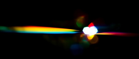 Wall Mural - Vibrant rainbow light streak across a dark background. Abstract, colorful, and mesmerizing.