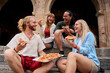 © CarlosBarquero - Funny group of young people and they have fun eating pizza in the touristic city. Italian friends having food outdoors, laughing in a casual street setting. Vibrant urban background and cheerful mood