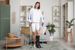 © Pixel-Shot - Young woman with broken leg and crutches walking at home