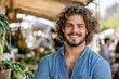 © netrun78 - Young handsome farmer smiling at the farmers market, showcasing the quality and freshness of local produce