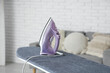 © Pixel-Shot - Electric iron on board in light room