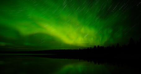 Wall Mural - panorama of bright green aurora with star streaks reflecting in a calm northern lake