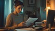 © Svitlana - Concerned Woman Reviewing Bills at Home at Night