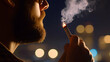 © Lailatul - Man smoking cigarette at night, city lights blurred background