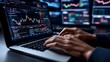© BerkahStock - Close-up of hands typing on laptop displaying stock market data charts and graphs on multiple screens.