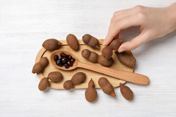 Wall Mural - Ripe tamarind on a wooden board on a light background