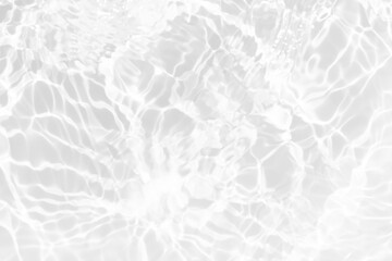 White water with ripples on the surface. Defocus blurred transparent white colored clear calm water surface texture with splashes and bubbles. Water waves with shining pattern texture background.