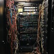 © NAIMAH - Messy server room cables, equipment rack, data center, tangled wires, IT infrastructure, networking