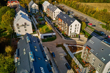 Wall Mural - Aerial view of modern residential neighborhood with contemporary apartment buildings, green spaces, parking areas and well-maintained pathways on sunny day