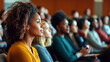 © Kanlayarawit - A diverse audience listening attentively to a speaker at an educational event during Black History Month, with banners and visuals celebrating Black culture.