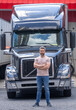 © Volodymyr - Truck driver. CDL. Portrait of trucker standing by his truck vehicle ready for transport. Male driver standing in front on his truck.