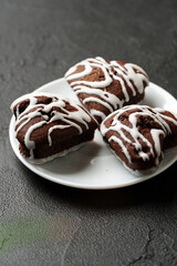 Poster - Delicious chocolate cookies with white icing on a plate, ready to be enjoyed in a cozy setting