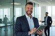 © Fazla - Portrait of a Smiling Confident Businessmen Holding a Digital Tablet in a Modern Office, Happy company executive, smiling businessman entrepreneur corporate leader Hr manager.
