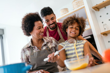 Wall Mural - happy black family in the kitchen having fun and cooking together. healthy food at home.