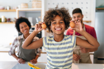 Wall Mural - happy black family in the kitchen having fun and cooking together. healthy food at home.