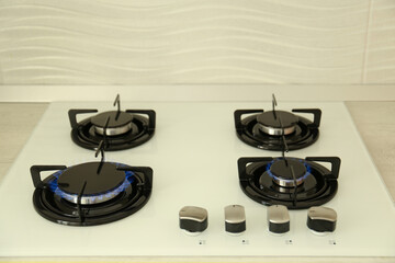 Wall Mural - Modern stove with burning blue flames in kitchen