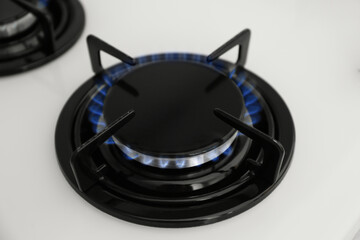 Wall Mural - Gas burner of modern stove with burning blue flame, closeup