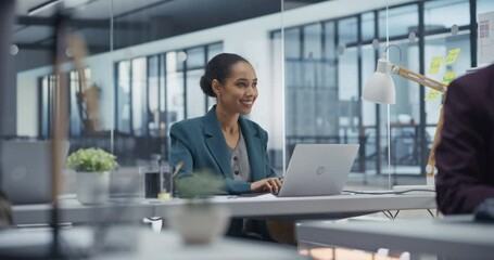Poster - African Female Marketing Manager Working Behind a Desk in Modern Office, Creating Social Media Content on Laptop Computer. She is Developing Engaging Posts to Promote Brand Awareness