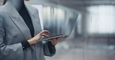 Aufkleber - Businesswoman Standing Next to a Window, Working on Laptop Computer in Office. Anonymous Female Manager Planning Investment Strategy for an e-Commerce Project. Close Up Footage with Focus on Hands