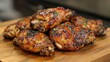 © VRVisionary - Savory roasted chicken wings glazed with sauce and garnished with herbs on a rustic wooden cutting board in a warm kitchen setting.
