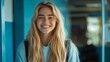© Alex Piatkowski - A joyful female student with long blonde hair, wearing a casual uniform, smiling warmly