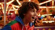 © Passion - Excited caucasian young boy enjoying colorful carnival ride at night