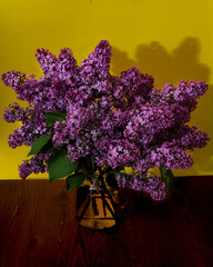 Wall Mural - Beautiful bouquet of lilacs in a glass jar on a wooden table