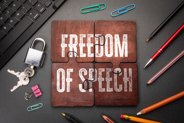 Wall Mural - freedom of speech. wooden puzzle pieces with text on a dark office table
