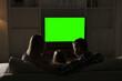 © New Africa - Family watching TV on sofa at home in evening