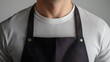 © Mariam - A man wearing a plain black apron and a white t-shirt