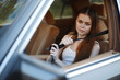 © SHOTPRIME STUDIO - Young woman fastening her seatbelt in a car, reflecting safety and confidence, with natural light and a warm color palette.