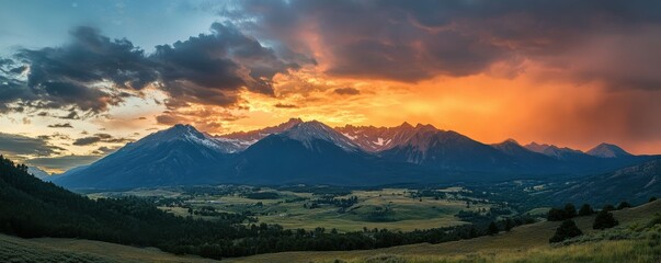 Wall Mural - A dramatic sunrise over a mountain range with clouds below the peaks.