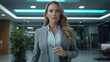 © Number One Studio - confident businesswoman in modern office setting, holding pen and looking directly at camera. Her professional attire and poised demeanor convey success and determination