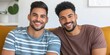 © Andrii Zastrozhnov - Two men are smiling and posing for a picture on a couch. Scene is happy and friendly