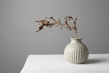 Wall Mural - Stylish vase with dry branch on white table